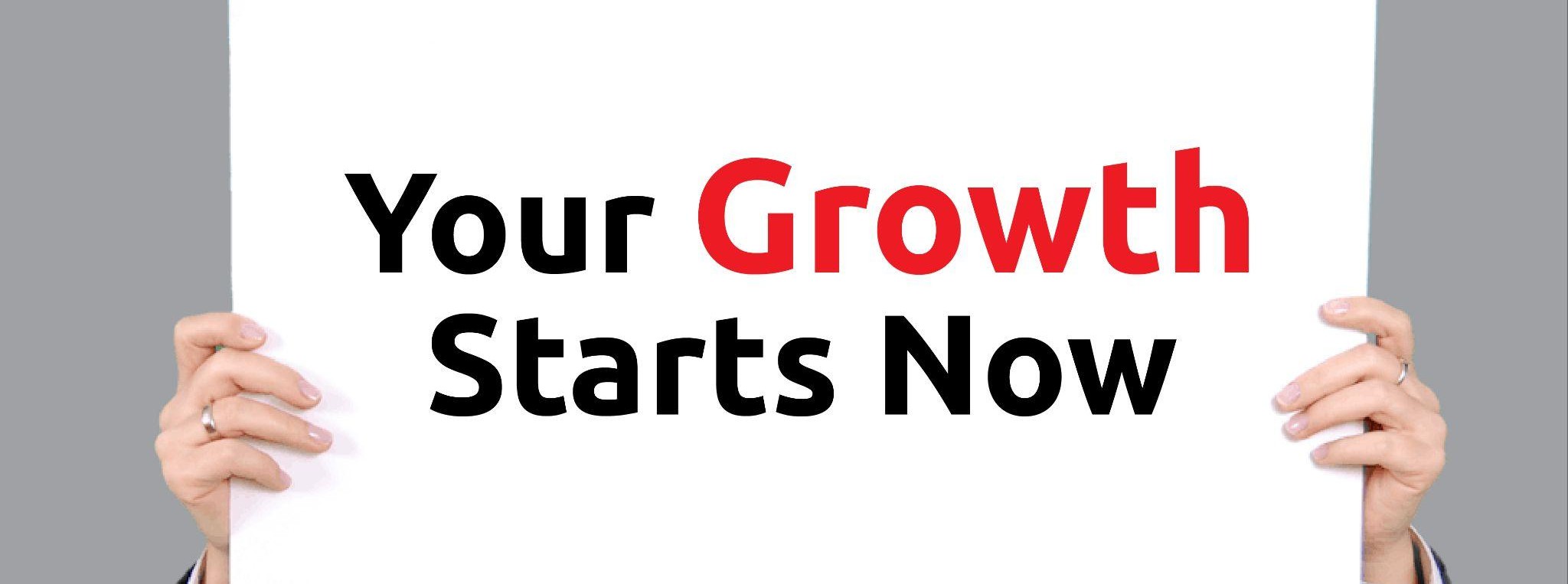 Business professional holding a sign that reads ‘Your Growth Starts Now’ in bold black and red text, representing small business marketing and brand growth strategies.